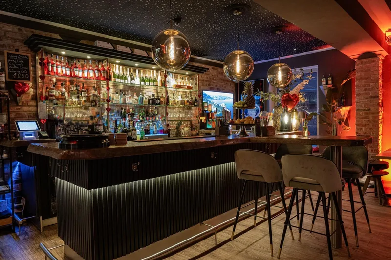 Die Bar der il Casale Lounge & Bar mit Barhockern und Spirituosenwand